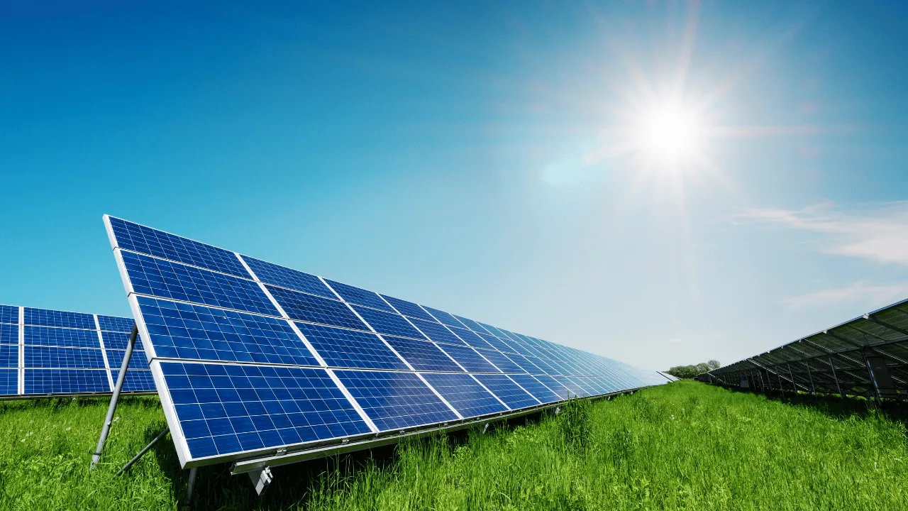 Paneles solares en un campo verde generando energía renovable bajo un cielo despejado y sol brillante, ideal para explicar la diferencia entre HSP y horas de sol