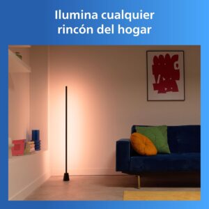 Lámpara de pie inteligente encendida con un tono cálido anaranjado bañado sobre la pared del salón.